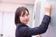 A woman in a business suit leaning against a wall.