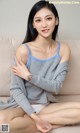 A woman sitting on a couch with her arms crossed.